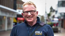 Jim Hall, RNLI face-to-face fundraiser wearing a blue RNLI fleece jacket on Poole high street